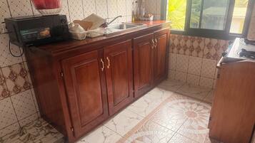 Una cocina con microondas, fregadero y armarios.