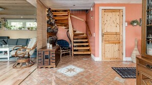 Een gezellige woonkamer met een houten trap, een bank en een bijzettafeltje.