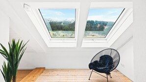 A room with two skylights, a black chair, and a plant. - Spacious Allgäu loft | maisonette style (Nesselwang)