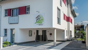 Een modern gebouw met een bord waarop staat dat het een wooncomplex is.