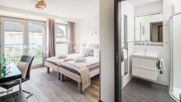Een moderne hotelkamer met een bed, een bureau en een badkamer.