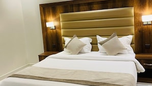 A modern hotel room with a large bed, wooden headboard, and two bedside lamps. - Doolve Riyadh 1 (Riyadh)