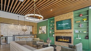Una sala de estar moderna con chimenea, estantes verdes y una zona de comedor.