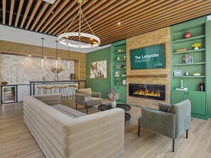 A modern living room with a fireplace, green shelves, and a dining area.