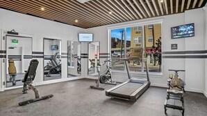 Un gimnasio con equipo de ejercicio, una cinta de correr y una bicicleta estática.