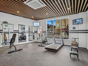 A gym with exercise equipment, a treadmill, and a stationary bike.