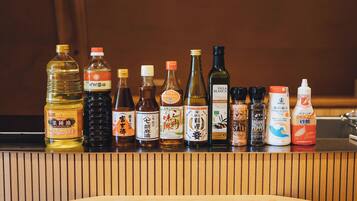 Variedad de botellas de condimentos sobre una encimera de madera.