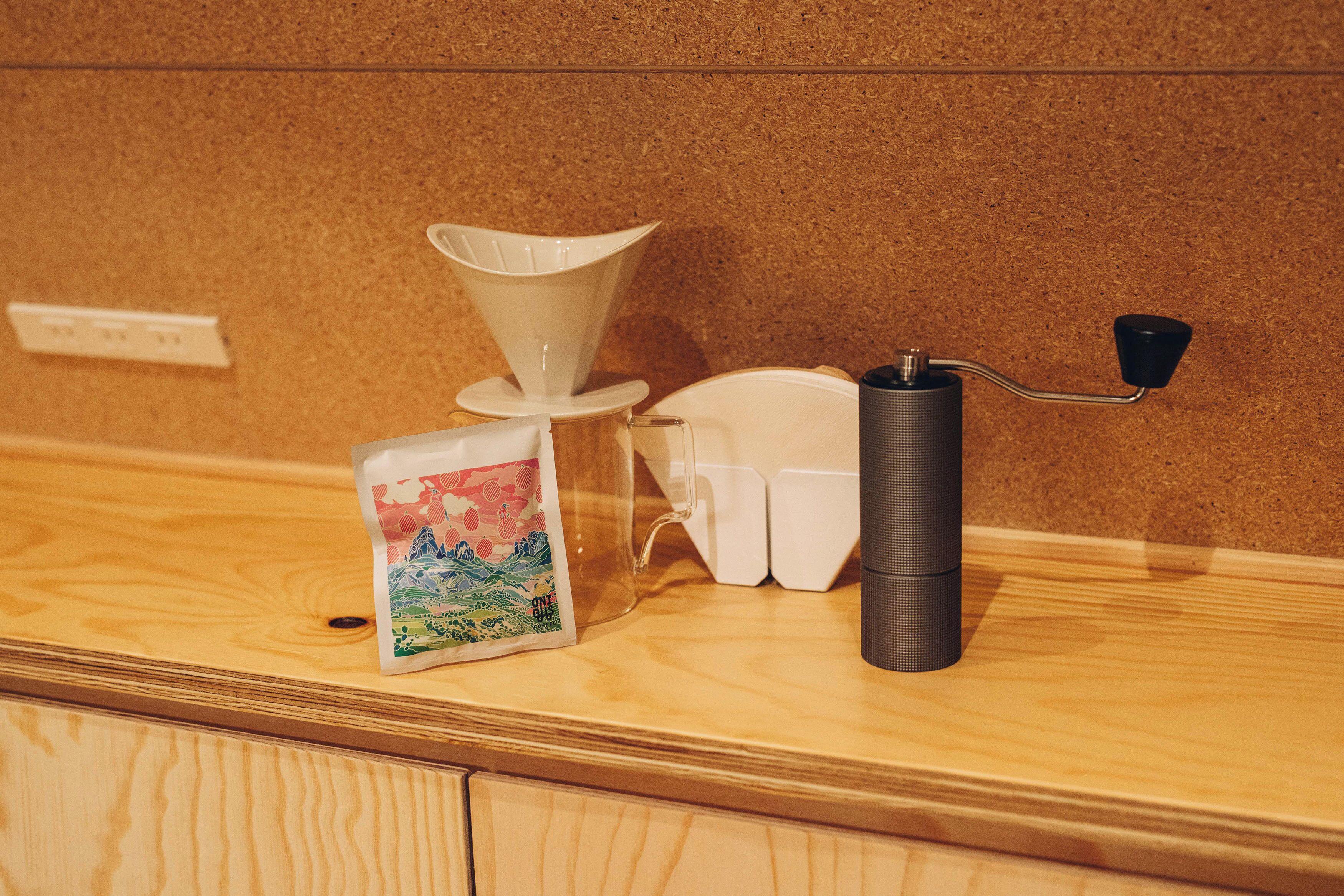 A coffee machine with a funnel and a black handle on a wooden counter.