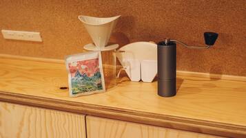 A coffee machine with a funnel and a black handle on a wooden counter.