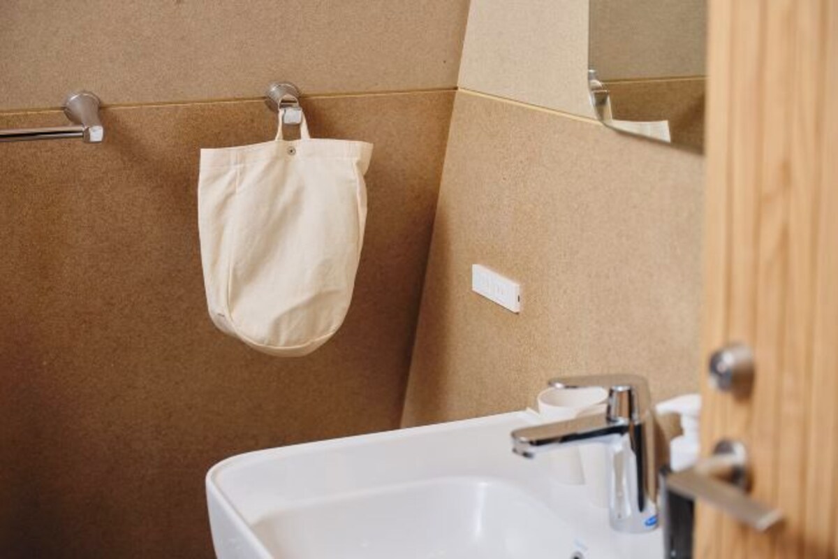 A bathroom with a white sink, a towel hanging on a rack, and a wooden door.