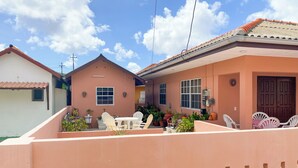 A residential house with a patio area, a dining set, and a large wooden door. - Cozy & Central Stay in Curaçao (Willemstad)