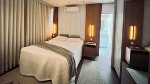 A modern hotel room with a large bed, two bedside tables, an air conditioning unit, and a view of the outside. - CM 304 - luxo conforto em frente ao mar  (Cabo Frio)