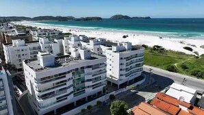 A coastal urban area with modern buildings, a beach, and a clear view of the ocean. - CM 304 - luxo conforto em frente ao mar  (Cabo Frio)
