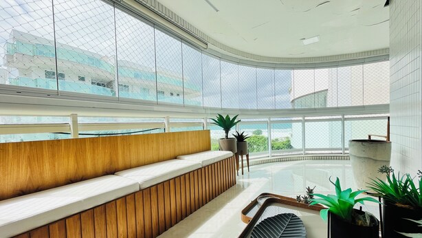 A modern interior with a curved wooden bench, potted plants, and a large leaf-shaped planter. - CM 304 - luxo conforto em frente ao mar  (Cabo Frio)