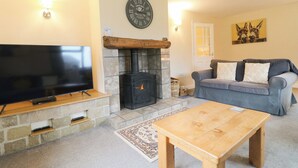 A living room with a fireplace, a flat-screen TV, a sofa, and a coffee table.