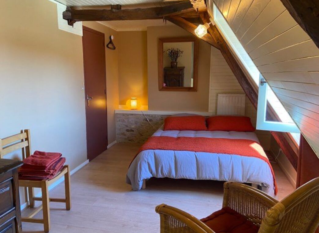 Une chambre à coucher avec un lit, une chaise, une commode et un miroir.