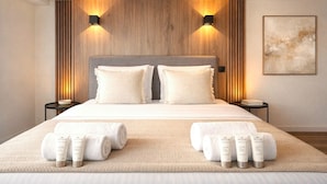 A hotel room with a large bed, two wall-mounted lights, a wooden headboard, a framed abstract painting, and toiletries on the bed. - 841 Polytech (Paris)