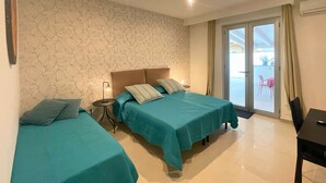 Habitación de hotel con dos camas, una mesita y una silla.
