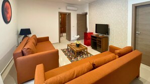 Una sala moderna con un juego de sofá, una mesa de centro, un televisor y un armario rojo.