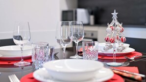 A dining table set with plates, glasses, and a small Christmas tree decoration. - [10min BGY Airport] Bilo Chic: garage + A/C (Seriate)