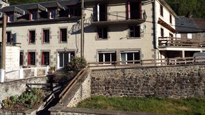 Ein mehrstöckiges Gebäude mit einer steinernen Fassade, zahlreichen Fenstern und Balkonen.