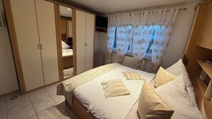 Un dormitorio con una cama grande, un armario y un baño.