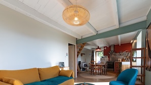 A living room with a sofa, a chair, a round table, and a hanging light fixture. - Holiday Home 'La Casita' with Mountain View, Private Terrace (Beauvène)