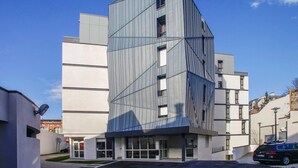 A modern building with a unique angular design, featuring large windows and a flat roof. - Chambre twin confortable à 10 min du centre ville (Orleans)