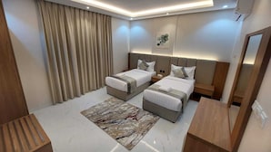 A modern hotel room with two beds, a marble floor, a wooden bench, and a large mirror.