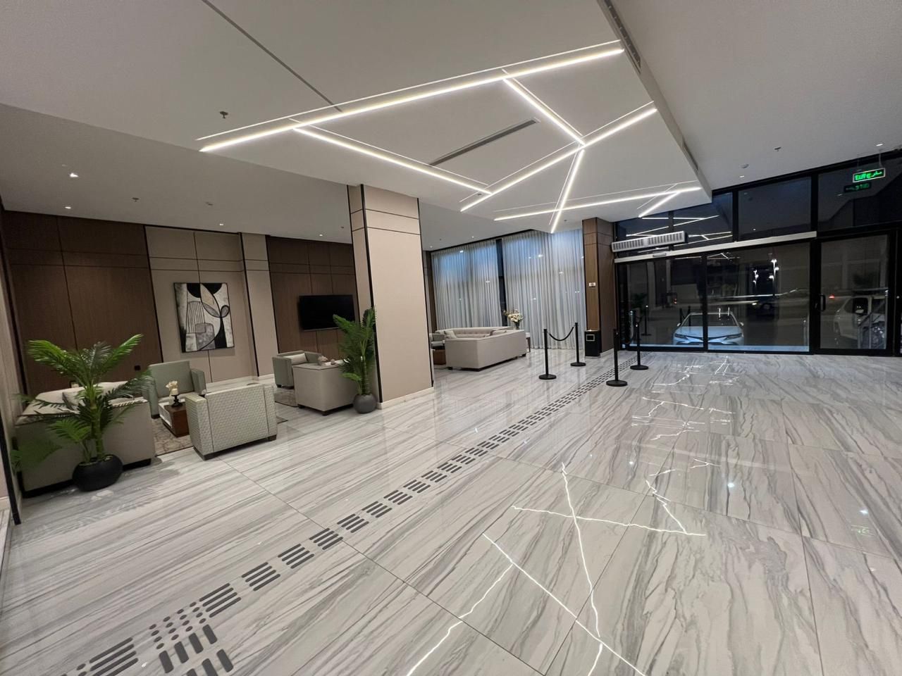 Eine moderne Lobby mit Marmorboden, Sitzbereich und Glastür.