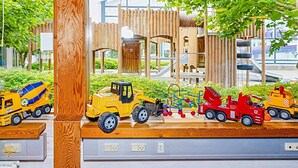 A children's play area with various toy vehicles and a wooden structure in the background. - 6 Person Holiday Home on a Holiday Park in Hanstholm (Hanstholm)