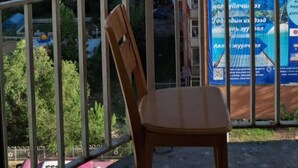 Un balcon offrant une vue sur le paysage urbain, avec des bâtiments et des montagnes en toile de fond.