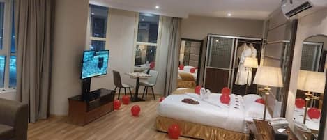 A hotel room with a bed, a desk, a television, and a wardrobe.