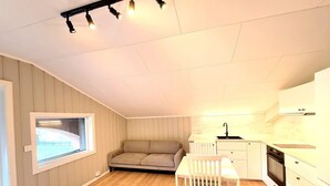 Et kompakt køkken med spiseplads, et vindue og en indbygget ovn.