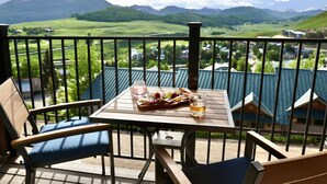A balcony with a table set for a meal, overlooking a mountainous landscape. - The Elk Mountain Escape (Mt. Crested Butte)