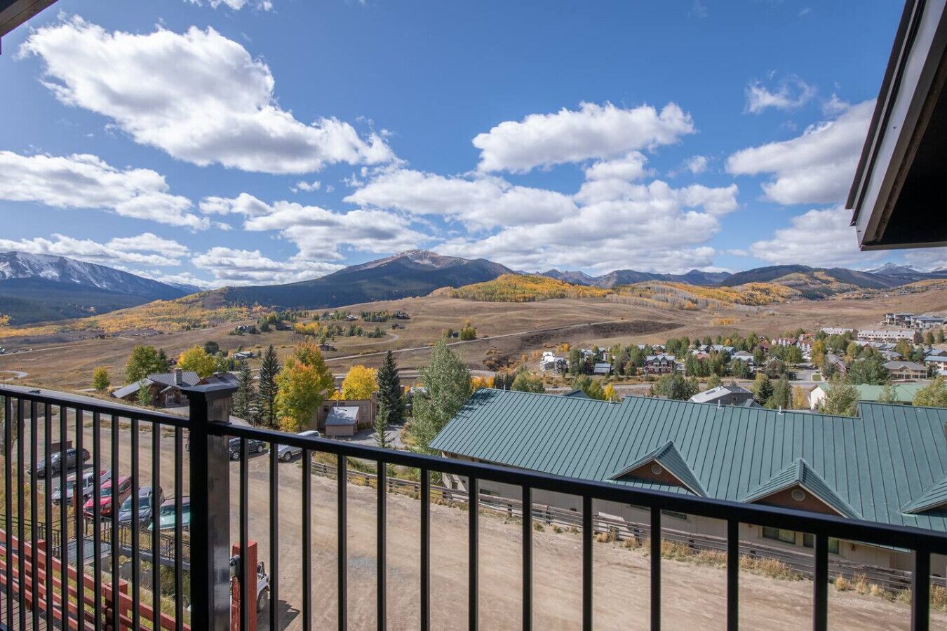 A balcony with a view of a mountain range and a small town below.