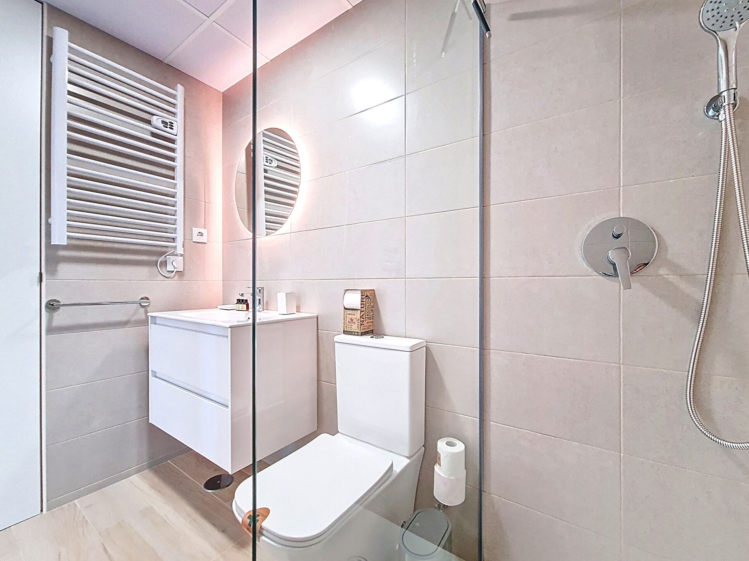 A modern bathroom with a toilet, sink, and shower.