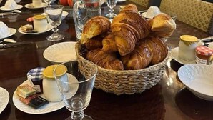 Desayuno con una exhibición de frutas, croissants y diferentes opciones sobre una mesa.