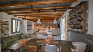 Una cocina moderna con pared de piedra, vigas de madera y espacio para platos empotrado.