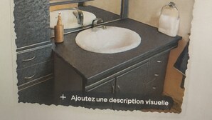 A bathroom with a dark countertop, a round sink, and a mirror with lights above it. - Gentle getaway near Beauval and the Châteaux (Romorantin-Lanthenay)