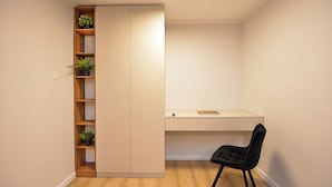 A compact room with a built-in wardrobe, a desk, and a chair. - Libra Apartment - Two Bedrooms - 5 Guests - Next To Cismigiu Gardens (Bucharest)
