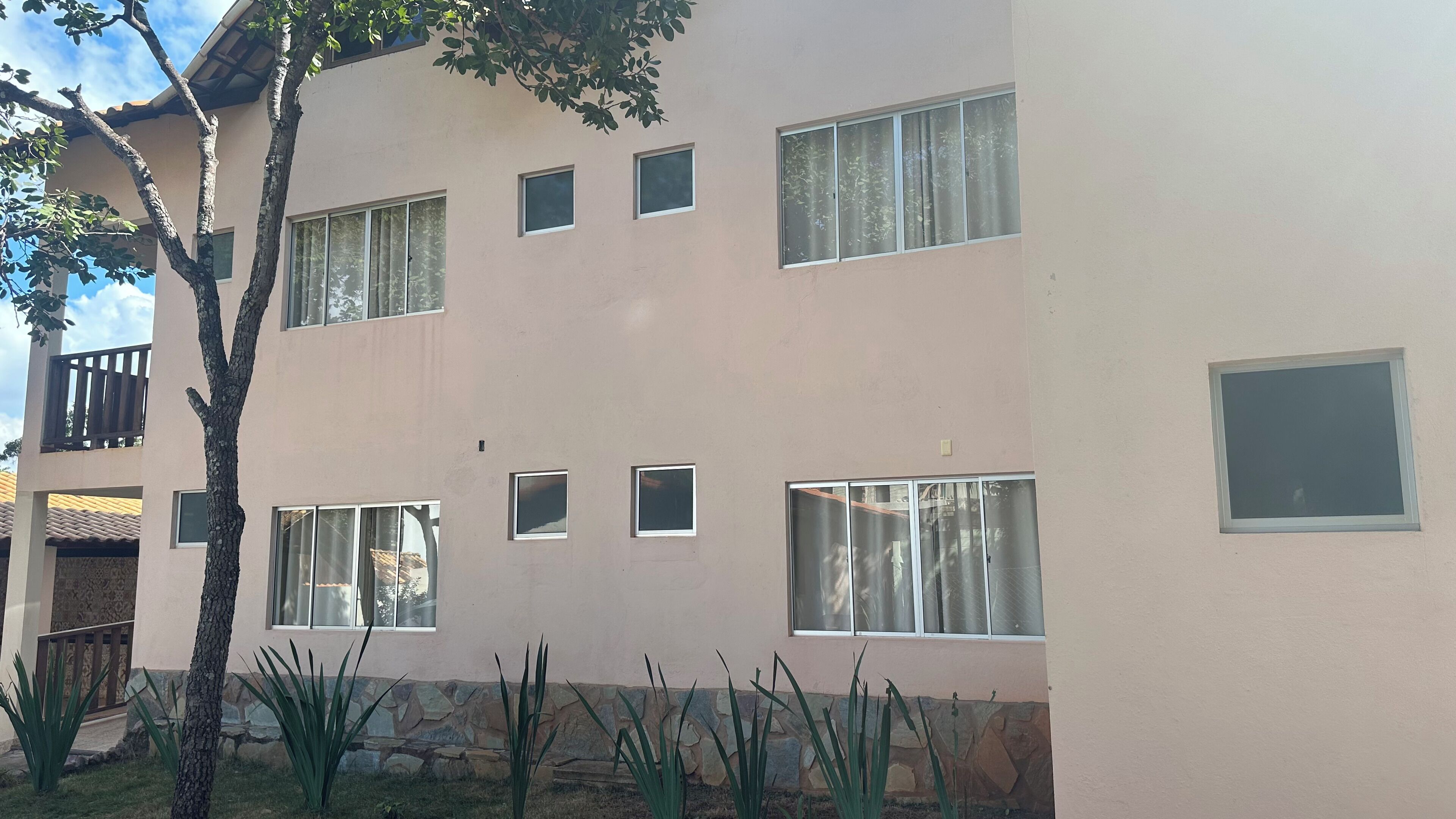 Un edificio de varios pisos con grandes ventanales y una base de piedra.