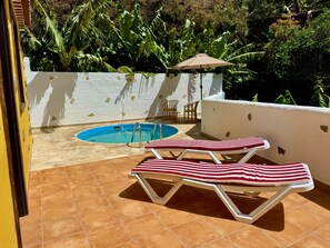 Ein Poolbereich mit Whirlpool, zwei Liegestühlen und einem kleinen Tisch.