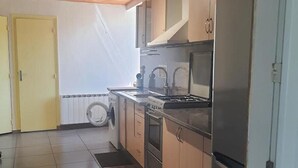 A kitchen with a washing machine, stove, and refrigerator. - Little corner of Paradise (Yssingeaux)