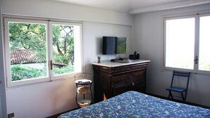 A bedroom with a bed, dresser, TV, and windows. - Villa Rosa in Marina di Maratea (Marina)