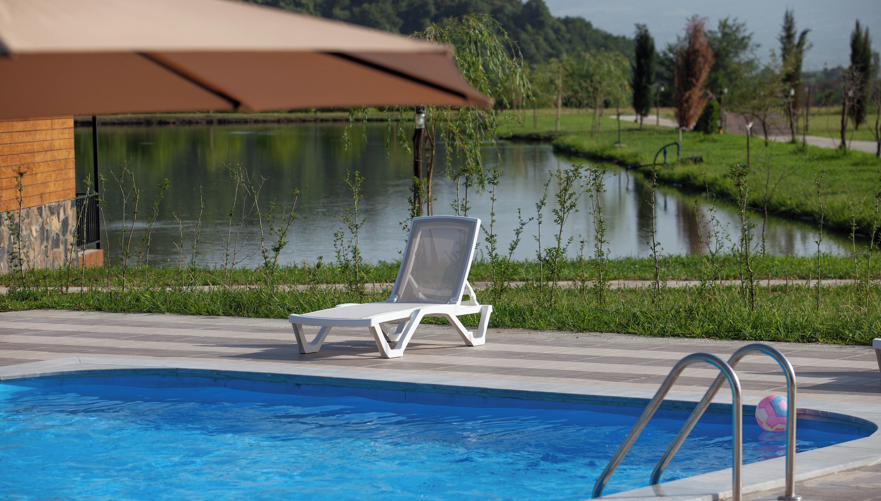 Una piscina con una silla de descanso y una escalera.