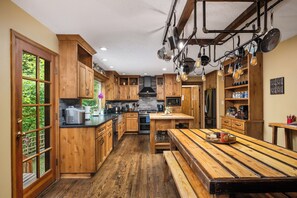 A kitchen with wooden cabinets, a central island, and a dining table.