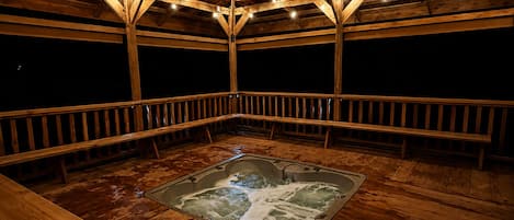 Eine Holzterrasse mit Whirlpool, Holzgeländern und einer Holzbalkenkonstruktion.