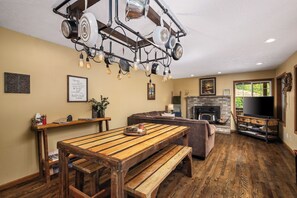 Un salon chaleureux avec un banc en bois, une cheminée et un téléviseur.