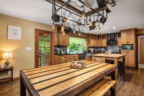 A kitchen with wooden cabinets, a central island, and hanging light fixtures.